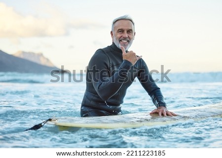 Senior man surfing in Hawaii beach, surf culture hands signal and healthy fitness in ocean nature. Friendly surfer easy greeting, retirement travel of elderly person and sea adventure lifestyle