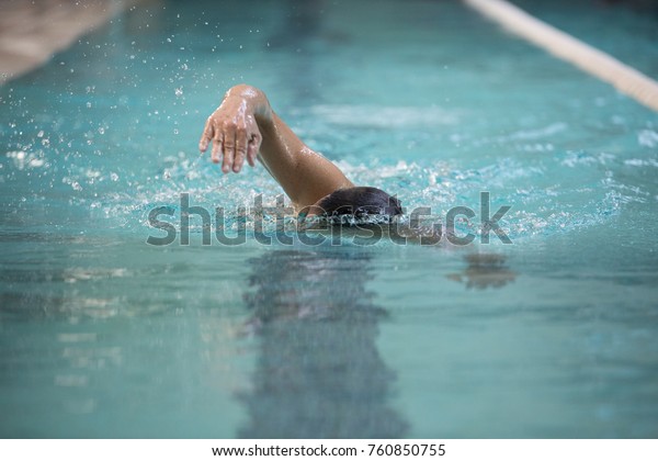 Senior man swimming in freestyle - Concept of sport\
and fun in swimming pool