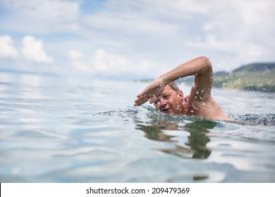 Senior man swimming in the Sea/Ocean - enjoying active retirement, having fun, taking care of himself, staying fit - Powered by Shutterstock