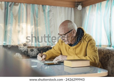 Senior man at table writing words in crossword with pencil and reading notes in smartphone in style of kitsch and camp charm, frequent use of yellow