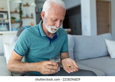 Senior Man Takes Pill With Glass Of Water In Hand. Stressed Mature Man Drinking Sedated Antidepressant Meds. Man Feels Depressed, Taking Drugs. Medicines At Work