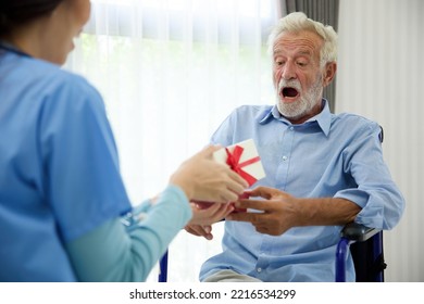 senior man taking a gift box from caregiver for happy birthday - Powered by Shutterstock