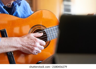 Senior Man Taking Guitar Online Lessons In Tablet