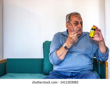 Senior Man Taking Medicine At Home. Older Man Taking Daily Medicine To Consume. Man Pouring A Pill From Into Hand. 