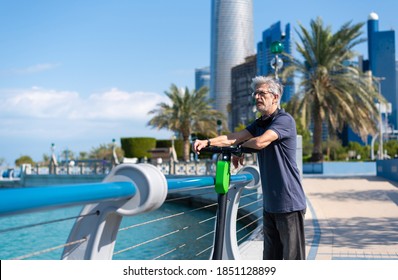 Senior man taking rest while having a ride on electric scooter for transportation in a modern city environment