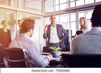 Senior man talking to employees in office meeting. Marketing team discussing new ideas with manager during a conference. Senior leadership training future businessmen and businesswomen. - Shutterstock ID 770245405