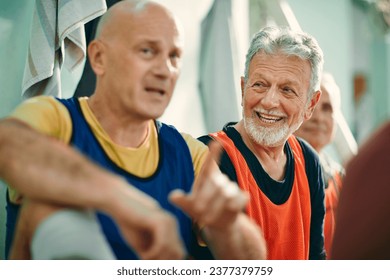 Senior man talking to his friends in the locker room after playing football together - Powered by Shutterstock