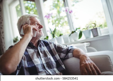 Senior Man Talking On Mobile Phone At Home