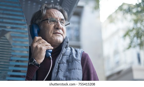  Senior Man Talking On Public Payphone In Outdoors