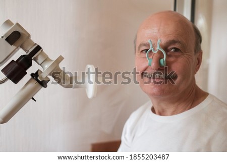 Senior man testing breathing function by spirometry. Take care about health.