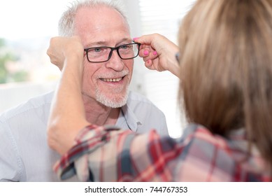 Senior man testing new eyeglasses in optician store - Shutterstock ID 744767353