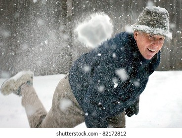 A Senior Man Throwing A Snowball