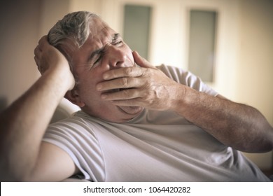 Senior Man Tired Sitting On Bed.  Close Up.