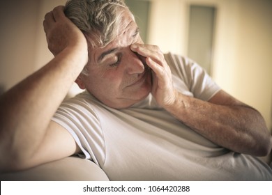 Senior Man Tired Sitting On Bed.  Close Up.