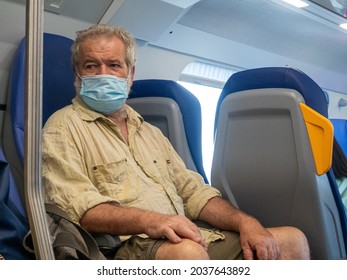 A Senior Man Traveling On A Bus With A Face Mas