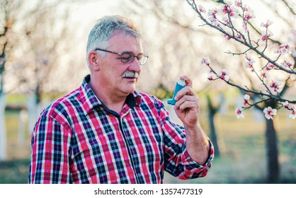 Senior Man Treating Asthma With Inhaler