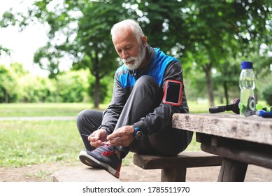 Senior man tying shoelace getting ready for workout at park - Powered by Shutterstock