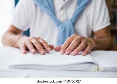 Senior man using braille to read in a retirement home - Powered by Shutterstock