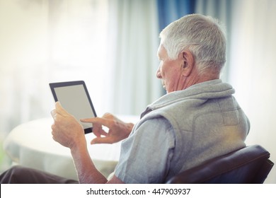 Senior Man Using Digital Tablet At Home
