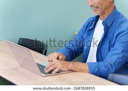 A senior man using a laptop computer