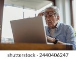 Senior man using laptop at home
