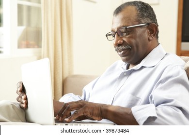 Senior Man Using Laptop At Home