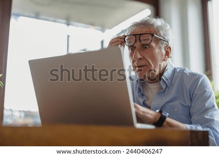 Senior man using laptop at home
