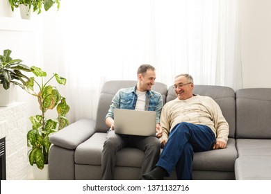 Senior man using laptop PC with his adult son