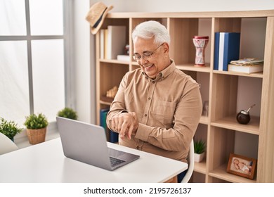 Senior Man Using Laptop Suffering For Wrist Pain At Home