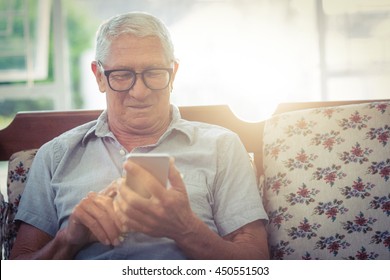 Senior Man Using Mobile Phone At Home