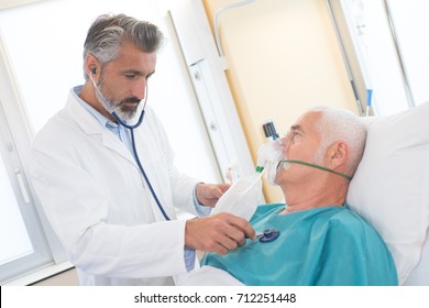 senior man using oxygen mask in clinic - Powered by Shutterstock