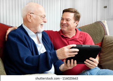 Senior man using tablet PC with his adult son. - Powered by Shutterstock