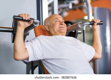 Senior Man  Using Trainer In Gym. 