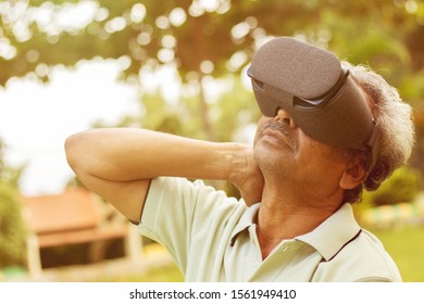 Senior Man Using VR Google Glass For Exercise, Outdoor - Fitness Concept Using New Technologies By Elderly People - Old Men Stretching Hands By Watching Virtual Reality Goggles.