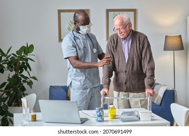 Senior Man Using Walkers While Visiting His Doctor At The Hospital, And Doctor Examining Him