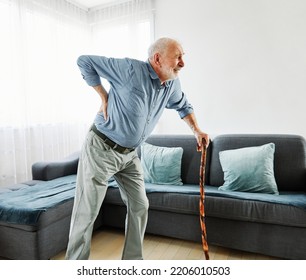 Senior Man Using A Walking Cane Having A Backpain At Home