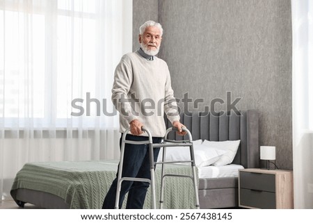 Senior man using walking frame at home