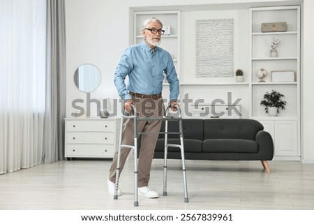 Senior man using walking frame at home
