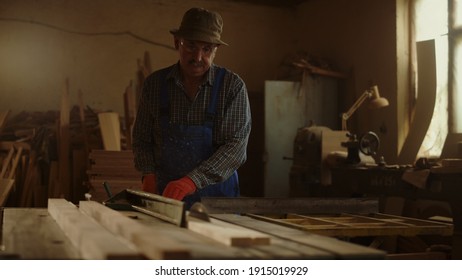 Senior man using wood lathe in carpentry workshop. Handyman making wood product in studio. Closeup elderly man working on saw machine indoors in slow motion. - Powered by Shutterstock