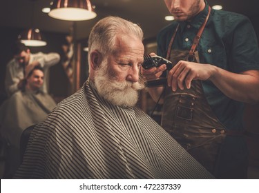 Senior Man Visiting Hairstylist In Barber Shop.