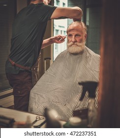 Senior Man Visiting Hairstylist In Barber Shop.