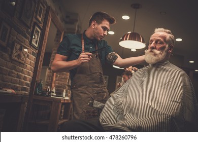 Senior Man Visiting Hairstylist In Barber Shop.