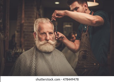 Senior Man Visiting Hairstylist In Barber Shop.