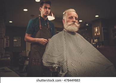 Senior Man Visiting Hairstylist In Barber Shop.