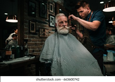 Senior Man Visiting Hairstylist In Barber Shop.