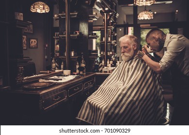 Senior Man Visiting Hairstylist In Barber Shop.