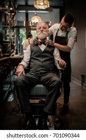 Senior Man Visiting Hairstylist In Barber Shop.