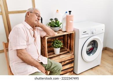 Senior Man Waiting For Washing Machine Sleeping On Chair At Laundry Room