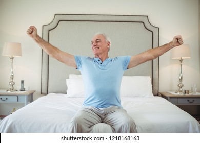 Senior Man Waking Up In Bed And Stretching His Arms 