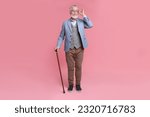 Senior man with walking cane on pink background